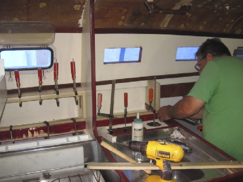 Terry gluing and screwing and clamping the galley and saloon cupboards in for us!