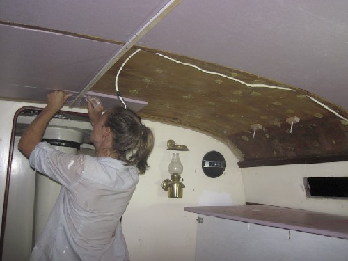 Jess putting up the last few bits of insulation in the cabin