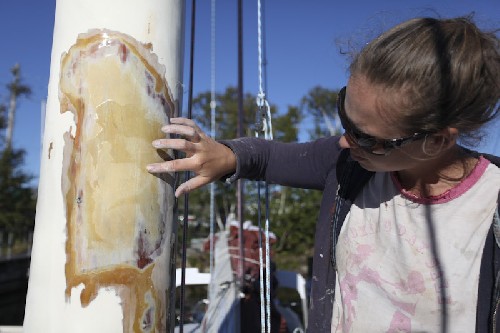 Jess sanding the fibreglass repair on the mast