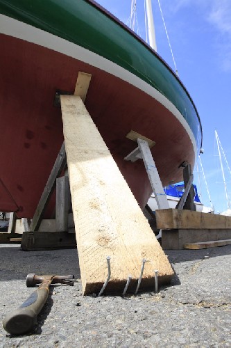 Quick! Shove a strut under it, and nail it into the ground to stop her being able to fall off the cradle!