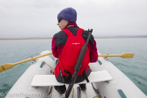 Jess rowing ashore to explore on Banks Island. Shotgun for polar bear defence.